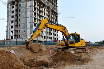 Excavator working at construction site on earthworks. Backhoe on road work and aying sewer pipes....