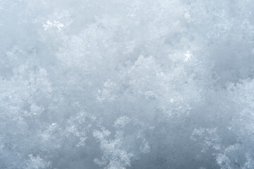 Background with close-up of snow under strong magnification. Slightly melted snow with sharp edges in soft focus.