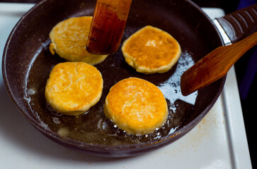 cooking small pancakes with delicious natural egg filling with cottage cheese, fry them in a pan and serve on a plate
