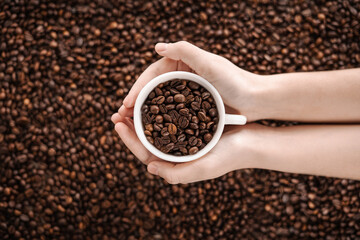 Сoffee beans in hand. View from above