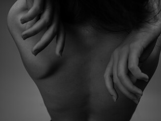 Black and white photo of a long hair model touching herself with hands