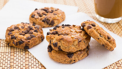 cookies with chocolate and hazelnuts and coffee with milk lie on the table