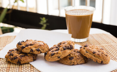 cookies with chocolate and hazelnuts and coffee with milk lie on the table