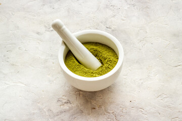 Henna powder in white mortar. Herbal natural hair dye