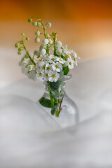 Spring flowers in a glass vase surrounded by veil