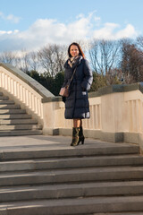 A young woman climbs the steps in the park. Autumn nature sunset