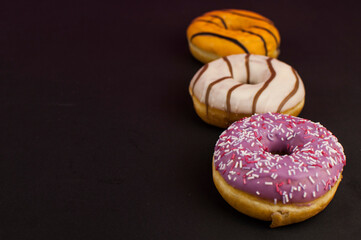 colorful donuts or doughnut on black paper background.