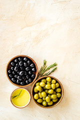 Top view of green and black olives in bowls with oil