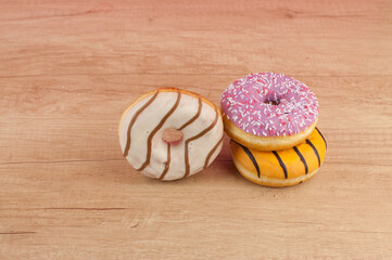 colorful donuts or doughnut on wooden table background.