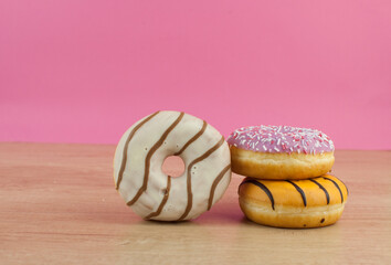 colorful donuts or doughnut on wooden table background.