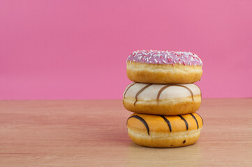 colorful donuts or doughnut on wooden table background.