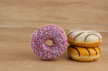 colorful donuts or doughnut on wooden table background.