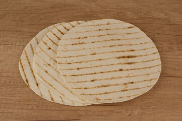 Fototapeta na wymiar Round tortilla wraps on wood table background. Top view.