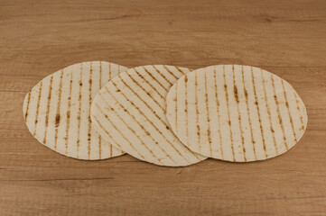 Round tortilla wraps on wood table background. Top view.