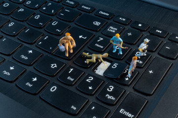 Mini Workers working on button on top of keyboard
