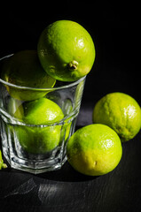 Fototapeta na wymiar green lemons on the black table
