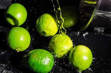 Fototapeta na wymiar green lemons on the black table