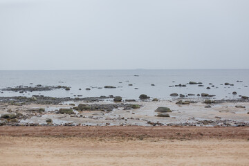The coast of the Gulf of Finland. Large granite stones on a sandy beach