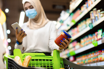 Muslim Lady Using Phone Buying And Scanning Food In Supermarket