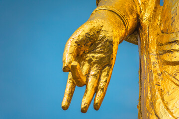 Close up on the hand of a golden Buddhist statue of Goddess of Mercy Kannon Bosatsu depicting a...