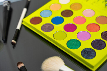 Various luxury makeup products on dark background, flat styling.