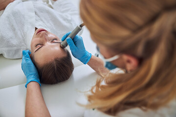 Beautiful elegant Caucasian female relaxing at the beauty procedure in wellness center