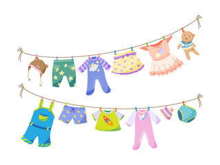Fototapeta na wymiar Baby fabric apparel. Baby girls and boys clothes hanging on clothesline. Drying children clothes and accessories after washing on rope. Shorts, socks, sweater, hat, toys, T-shirt, sarafans