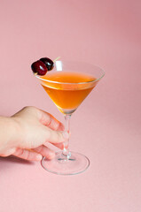 glass manhattan cocktail on pink background