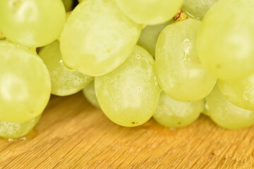 Several sweet berries of grapes on a wood table, close-up.