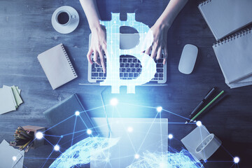 Double exposure of woman hands working on computer and blockchain theme hologram drawing. Top View. bitcoin cryptocurrency concept.