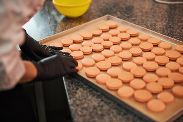 Talented confectioner preparing a tray full of delicious macarons