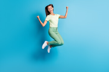 Fototapeta na wymiar Full length body size photo of pretty girl gesturing like winner jumping high laughing isolated on vibrant blue color background