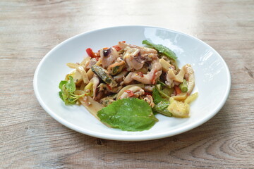 spicy stir fried squid with mussel and mashed pork couple bamboo shooting  basil leaf on plate