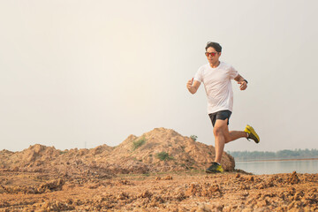 Outdoor trail running in early sunrise concept for exercising, fitness and healthy lifestyle. Young people running on country trail path. Athletes Sport Man Trail Running in the Forest.
