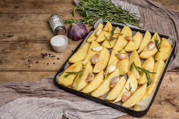 Spiced pieces of raw potato prepared to bake on old table
