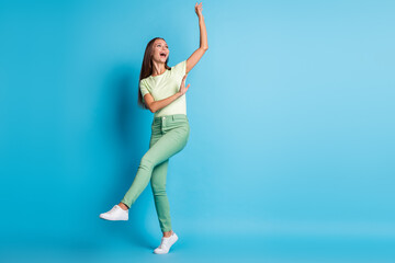 Full length body size photo of dancing girl looking blank space in casual clothes isolated on vivid blue color background