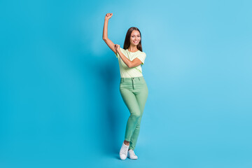 Fototapeta na wymiar Full size photo of optimistic brunette lady dance wear t-shirt trousers sneakers isolated on blue color background