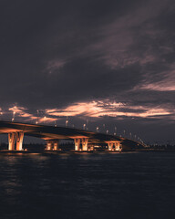 Fototapeta na wymiar dark clouds over bridge and orange sky