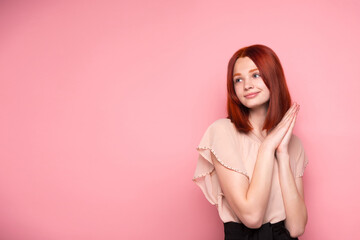 The red-haired girl is bright, sweet and gentle. On a pink solid background. Transparent healthy skin.