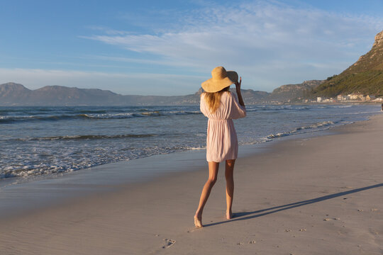 Caucasian Woman Wearing Beach Cover Up And Hat Having Fun Walking At The Beach