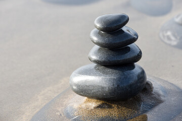 Fototapeta na wymiar Pebble stack on the beach the stones represent balance and wellbeing of the mind