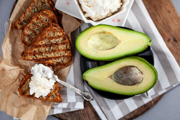 Sandwiches with soft cheese, avocado and cucumber. Breakfast is on the table. Healthy food. Toast and spread on it. Avocado sandwich stilllife. Healthy food. Toast.