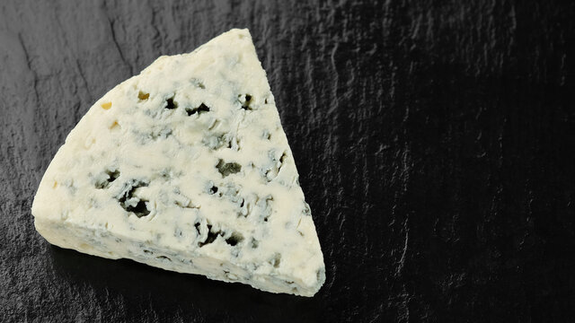 Piece Of Blue Cheese Isolated On Black Stone Plate, Top View