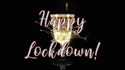 The ironic text message Happy Lockdown, appearing over a chalice of champagne surrounded by bright flying sparkles.
