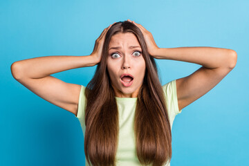 Fototapeta premium Photo of upset shocked young woman wear green outfit arms head open mouth isolated blue color background