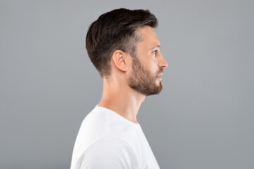Profile portrait of middle-aged man over grey background