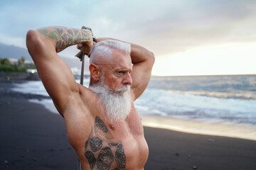 Fit and muscular senior man exercising on the beach. In a healthy body, healthy mind.