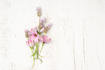 bunch of spring flowers on a wooden background with copy space