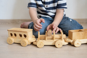 Little boys hands playing with wooden train