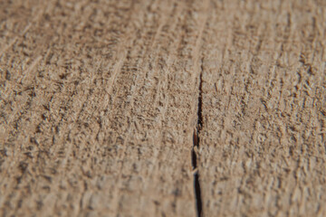 Fototapeta na wymiar Uneven structure of the wooden surface with a small crack in the macro image. Selective focus